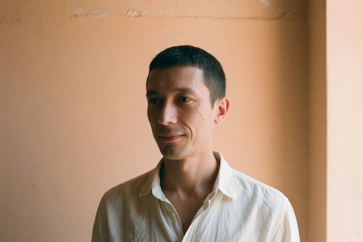 Portrait of Tom Kench in a linen shirt, standing beside a warm plaster wall